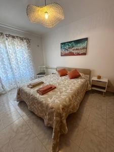 a bedroom with a large bed and a chandelier at Casa Sardine in Santo Isidoro