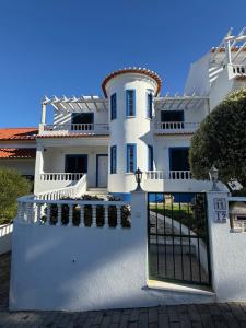 a white house with a gate in front of it at Casa Sardine in Santo Isidoro