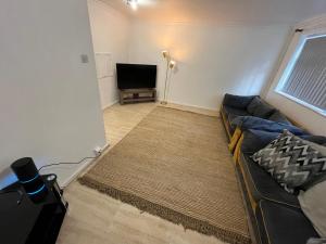 a living room with a couch and a flat screen tv at 3 bedroom Luxurious Property in Manchester
