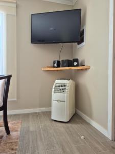 a room with a radiator and a tv on a wall at Cabañas San Luis in Colbún