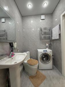 a bathroom with a sink and a washing machine at Walk Everywhere & Tourist Pick & Центр Города Алматы in Almaty