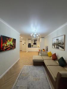 a living room with two couches and a chandelier at Walk Everywhere & Tourist Pick & Центр Города Алматы in Almaty