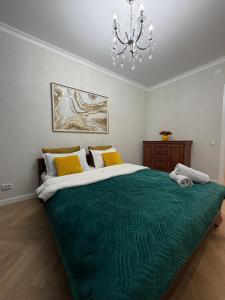a bedroom with a large green bed with a chandelier at Walk Everywhere & Tourist Pick & Центр Города Алматы in Almaty