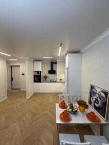 a living room with a table and a kitchen at Walk Everywhere & Tourist Pick & Центр Города Алматы in Almaty