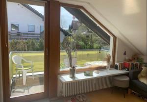 a living room with a window with a view of a tennis court at Gemütliche 3 Zimmerwohnung in Ühlingen-Birkendorf