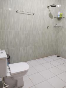 a bathroom with a white toilet and a shower at Rosa cheirosa in Barreirinhas +54 photos