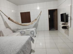 a room with a hammock and a tv in it at Rosa cheirosa in Barreirinhas