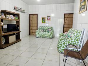a waiting room with two chairs and a television at Rosa cheirosa in Barreirinhas