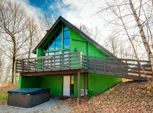 a green house with a large balcony on top of it at Mountain View 148 - 4 chambres - 13 personnes in Beaupré