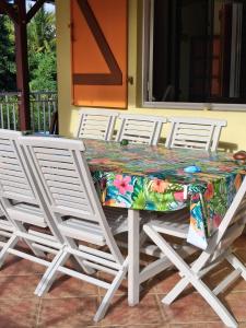 a table with chairs and a colorful table cloth on it at RESIDENCE LA TAUPINE MANDARINE in Le Diamant