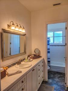a bathroom with a sink and a mirror and a tub at Beverlys Hilltop Retreat in Fallbrook +14 photos