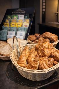 three baskets of bread and pastries on a table at Hôtel Belle Fontainebleau in Fontainebleau