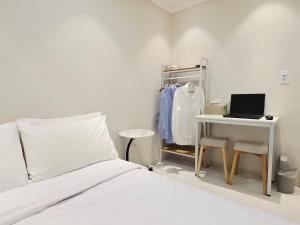 a bedroom with a bed and a desk with a laptop at Han River KS Stay in Seoul