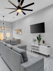 a living room with couches and a flat screen tv at 10 Mins from NRG 3BR 3BA in Houston
