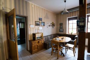 a living room with a table and a tv at Svečių namai Lingės in Nemėžis
