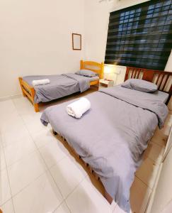 a bedroom with two beds and a window at Mersing 746homestay-9pax in Mersing +5 photos