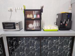 a kitchen counter with a toaster oven and a microwave at Mersing 746homestay-9pax in Mersing