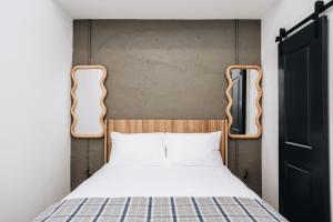 a bed with a wooden headboard in a room at The Harriss in Wilson