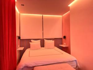 a small bedroom with a bed with red curtains at Appartement convivial pour séjourner in Le Kremlin-Bicêtre