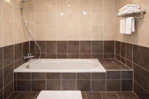 a bathroom with a bath tub in a room at Hôtel Belle Fontainebleau in Fontainebleau +16 photos