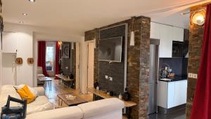 a living room with a white couch and a brick wall at Appartement convivial pour séjourner in Le Kremlin-Bicêtre