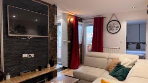 a living room with a couch and a flat screen tv at Appartement convivial pour séjourner in Le Kremlin-Bicêtre