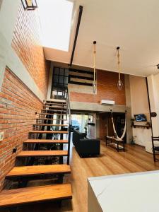 a loft with a staircase and a brick wall at Casa Estilo Industrial in Encarnación