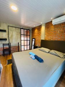 a large bed with two blue pillows on it at Casa Estilo Industrial in Encarnación