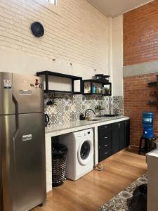a kitchen with a refrigerator and a washing machine at Casa Estilo Industrial in Encarnación +10 photos
