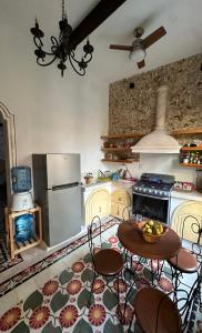 a kitchen with a table and chairs and a stove at Casa Bahareque Merida in Mérida