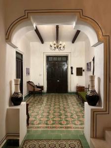 a hallway with two vases on display in a building at Casa Bahareque Merida in Mérida