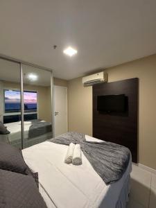 a bedroom with a bed with two white shoes on it at Mandai Apart - Beira Mar in Cabo Frio