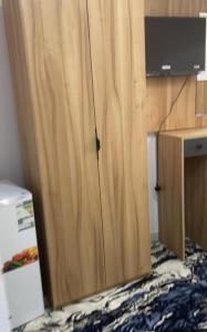 a wooden cabinet with a television on top of a desk at فندق اوتاد المتحدة المعابدة in An Naqāʼ