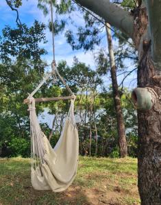 a white hammock hanging from a tree at Cabin on the Creek in Boyne Island +5 photos
