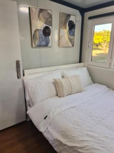 a bedroom with a white bed with three pictures on the wall at Cabin on the Creek in Boyne Island