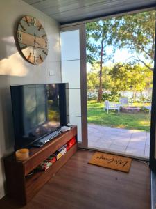 a living room with a tv and a clock on the wall at Cabin on the Creek in Boyne Island