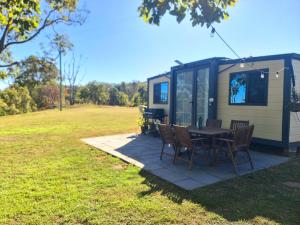a table and chairs in front of a tiny house at Cabin on the Creek in Boyne Island