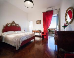 a bedroom with a bed and a table and a mirror at B&B Dumbolo in Pozzuoli