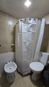 a bathroom with a toilet and a white shower curtain at Departamento b privado cerca arena Maipú p4 personas cochera in Maipú +4 photos