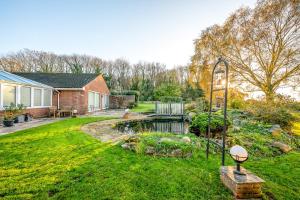 a garden with a pond and a house at Randall Farm Near Brands Hatch Circuit in Fawkham +50 photos