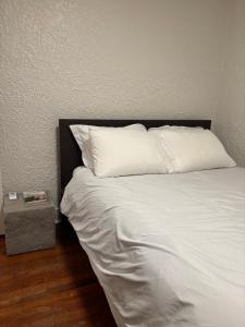 a bed with a white pillow and a side table at Pittsburgh Getaway - Private Home- 2 Beds in Pittsburgh