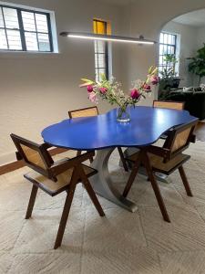 a blue table with a vase of flowers on it at Pittsburgh Getaway - Private Home- 2 Beds in Pittsburgh