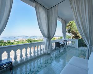 a balcony with white curtains and a table and chairs at B&B Dumbolo in Pozzuoli