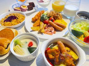 a table with plates of food and bowls of food at HOTEL AMANEK Asahikawa in Asahikawa