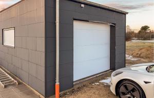 a garage with two doors on the side of a building at Awesome Home In Ringkøbing With Wifi in Ringkøbing