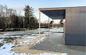 a building with an open door in the snow at Awesome Home In Ringkøbing With Wifi in Ringkøbing +10 photos