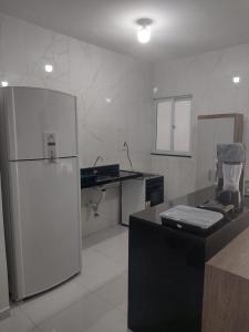 a white kitchen with a refrigerator and a counter at AZURE residence in Caucaia