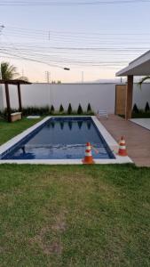 a swimming pool with two orange cones in a yard at AZURE residence in Caucaia