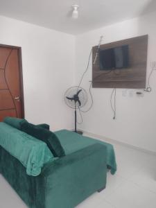 a bedroom with a green bed and a tv at AZURE residence in Caucaia