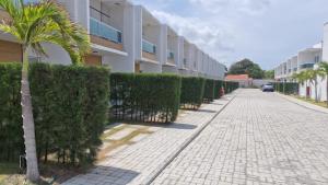 a sidewalk with a palm tree next to a building at AZURE residence in Caucaia